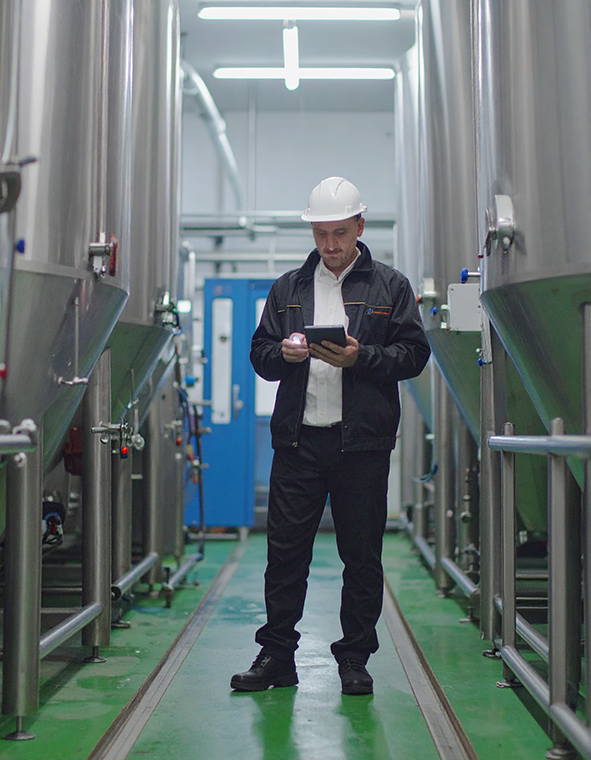 A male pest control technician at a Food Processors & Manufacturing Facility
