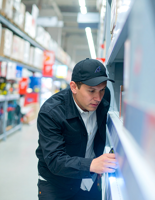 man inspecting shelves in a store